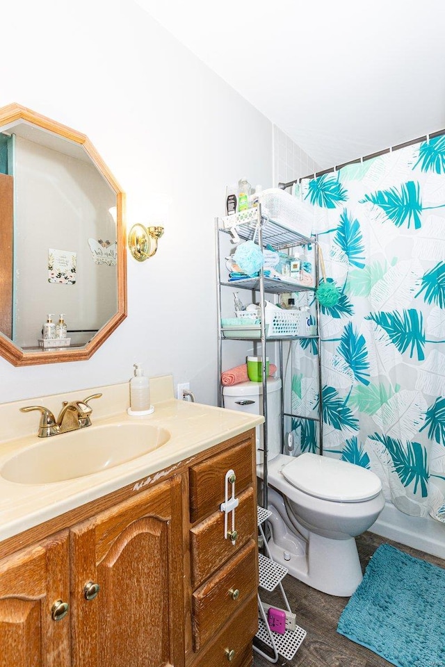 full bathroom with hardwood / wood-style flooring, shower / tub combo with curtain, vanity, and toilet