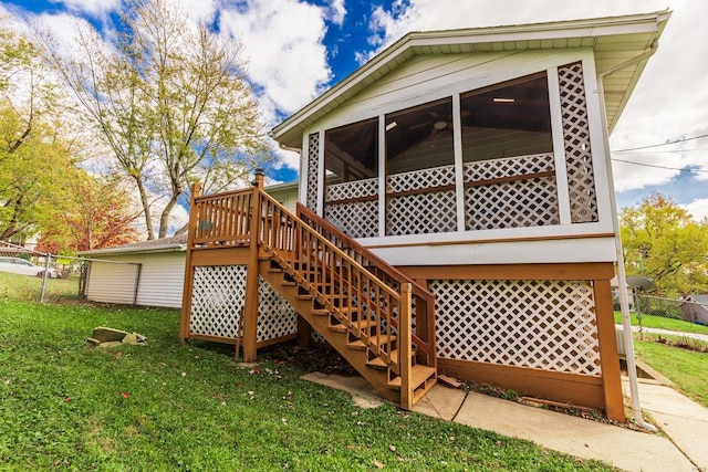 wooden terrace featuring a sunroom and a lawn