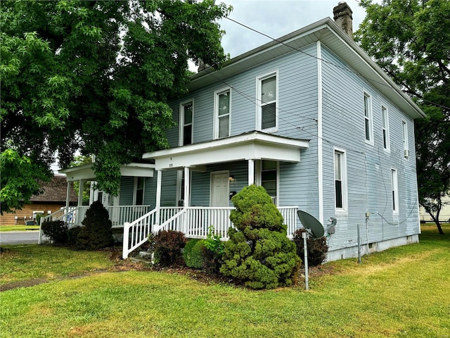 view of front of home with covered porch and a front lawn