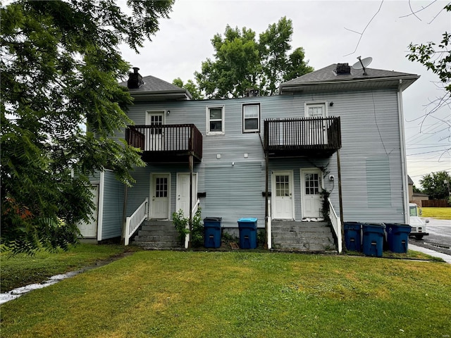 back of house with a yard and a balcony