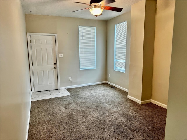 carpeted foyer entrance with ceiling fan and a textured ceiling