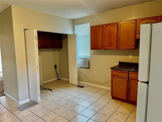 kitchen with cooling unit, a textured ceiling, light tile patterned floors, and white refrigerator