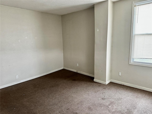 carpeted spare room with a textured ceiling