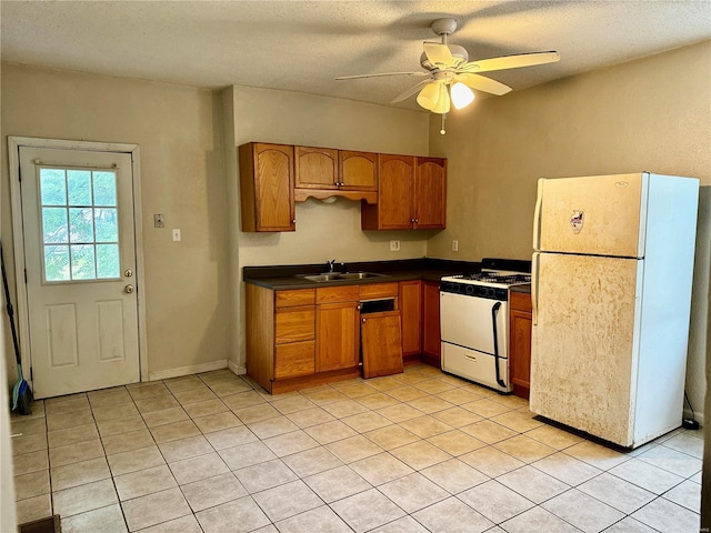 kitchen with sink, light tile patterned floors, a textured ceiling, white appliances, and ceiling fan