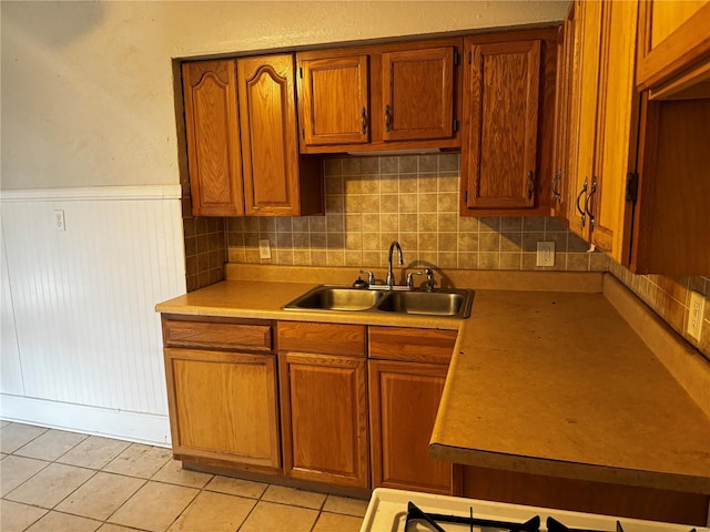 kitchen with light tile patterned flooring, sink, and backsplash