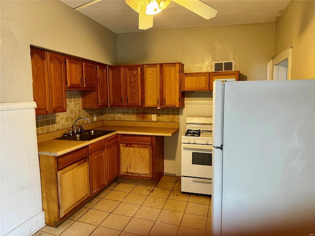 kitchen featuring decorative backsplash, sink, light tile patterned flooring, white appliances, and ceiling fan