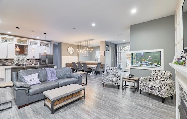 living room featuring an inviting chandelier and light hardwood / wood-style flooring