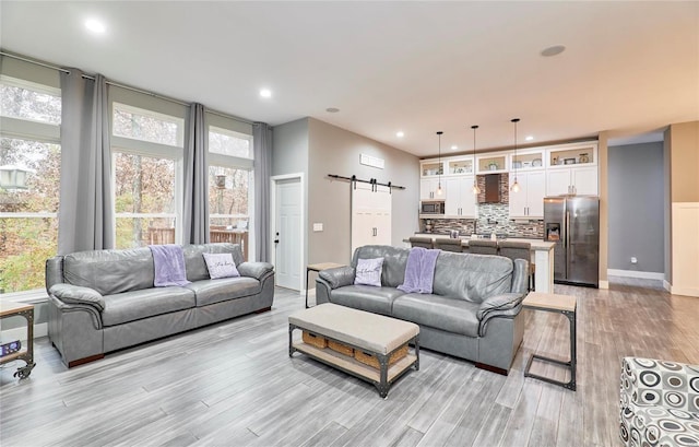 living room featuring a barn door and light hardwood / wood-style floors