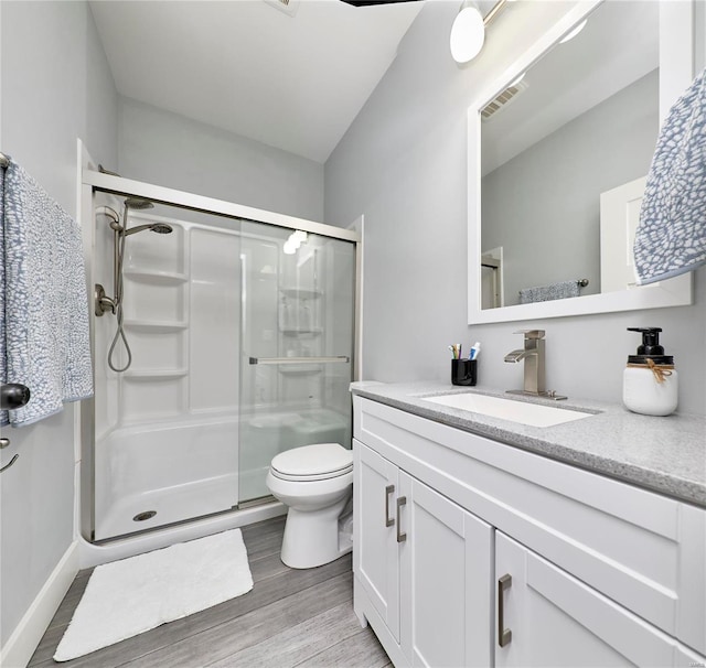 bathroom featuring an enclosed shower, vanity, toilet, and wood-type flooring