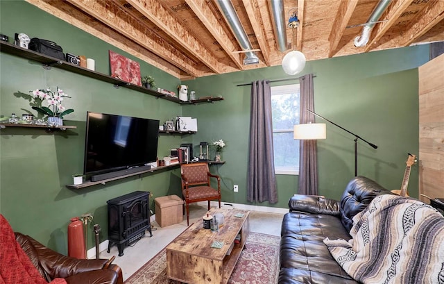 living room featuring concrete floors and a wood stove