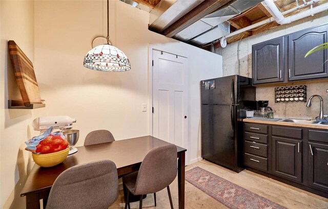 kitchen with black refrigerator, backsplash, and sink