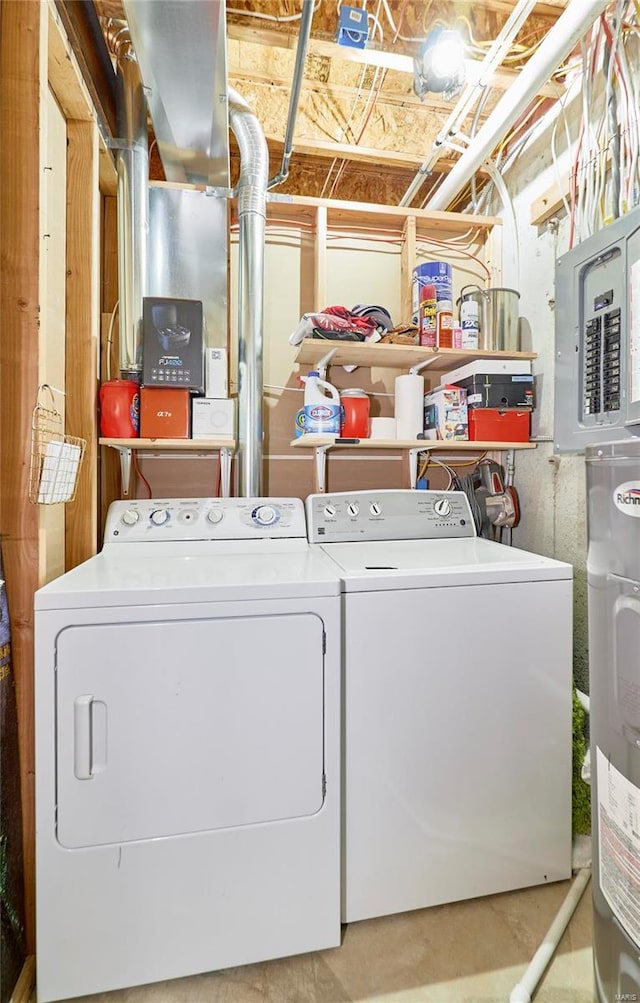 clothes washing area featuring electric panel, water heater, and washer and dryer