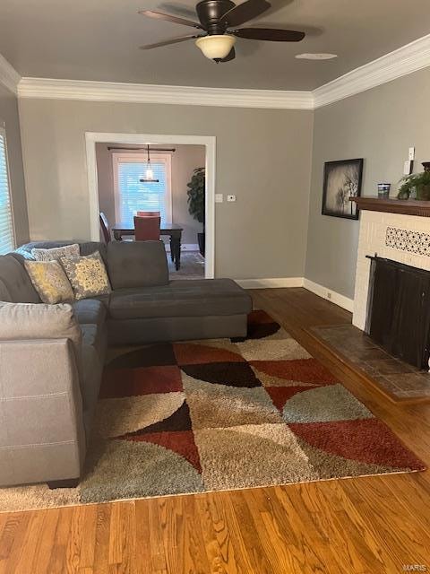 living room featuring crown molding, dark wood-type flooring, and ceiling fan