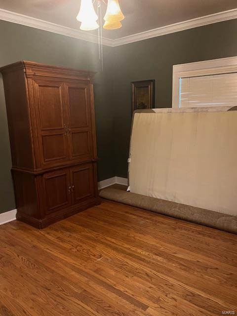 spare room with crown molding and wood-type flooring