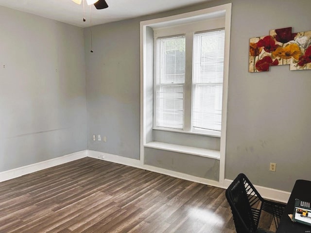 unfurnished office with ceiling fan, dark hardwood / wood-style floors, and a healthy amount of sunlight