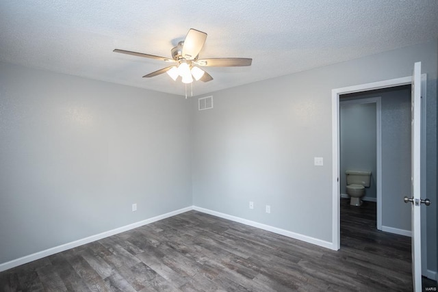 empty room with ceiling fan, a textured ceiling, and dark hardwood / wood-style flooring