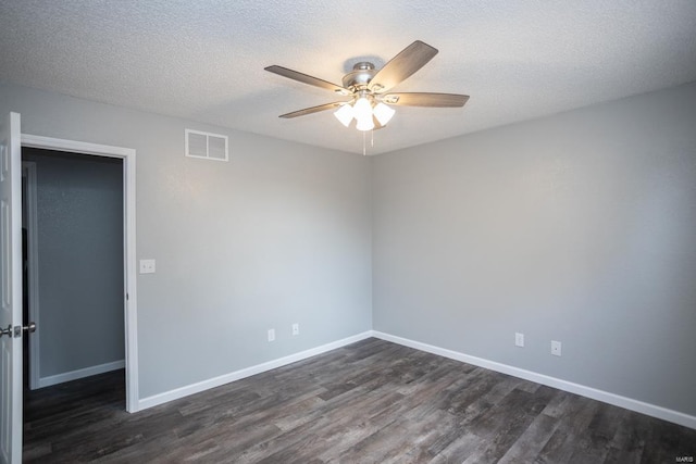 spare room featuring a textured ceiling, dark wood-type flooring, and ceiling fan