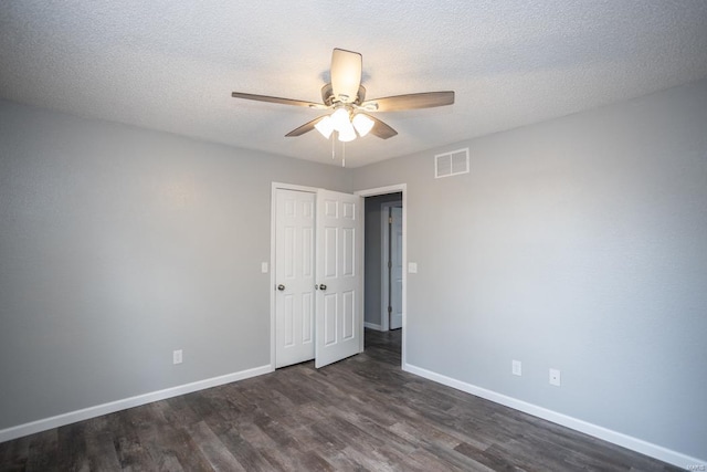 spare room featuring a textured ceiling, ceiling fan, and dark hardwood / wood-style flooring