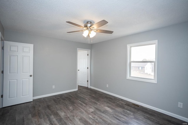 empty room featuring a textured ceiling, dark wood-type flooring, and ceiling fan