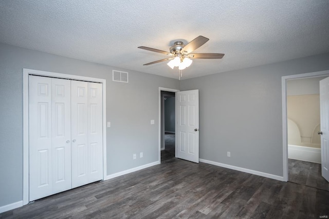 unfurnished bedroom featuring dark hardwood / wood-style flooring, a textured ceiling, a closet, and ceiling fan