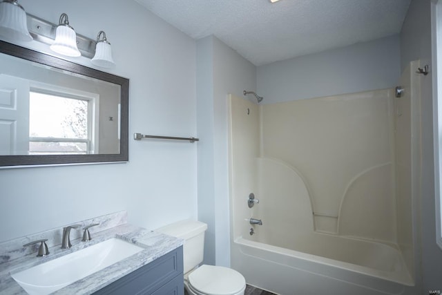 full bathroom featuring toilet, shower / tub combination, vanity, and a textured ceiling