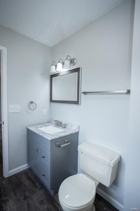 bathroom with vanity, toilet, and hardwood / wood-style flooring