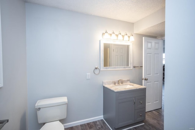 bathroom with vanity, hardwood / wood-style floors, a textured ceiling, and toilet