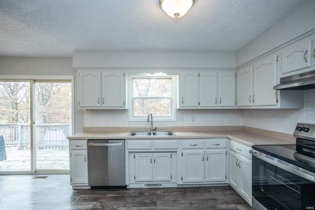 kitchen with decorative backsplash, dark hardwood / wood-style flooring, appliances with stainless steel finishes, white cabinetry, and sink