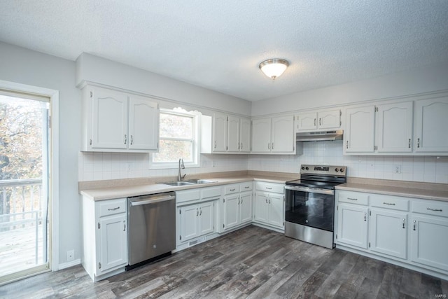 kitchen with white cabinets, stainless steel appliances, sink, and dark hardwood / wood-style flooring