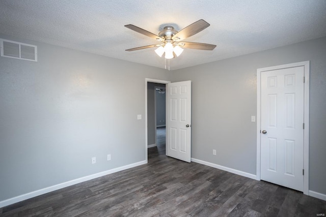 unfurnished bedroom featuring ceiling fan, a textured ceiling, and dark hardwood / wood-style flooring