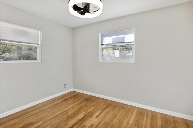 unfurnished room with hardwood / wood-style flooring and a healthy amount of sunlight