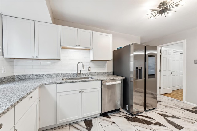 kitchen with white cabinets, light hardwood / wood-style floors, sink, and appliances with stainless steel finishes