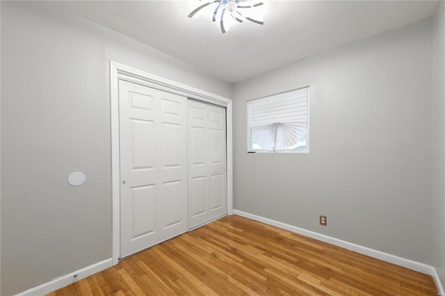 unfurnished bedroom with wood-type flooring and a closet