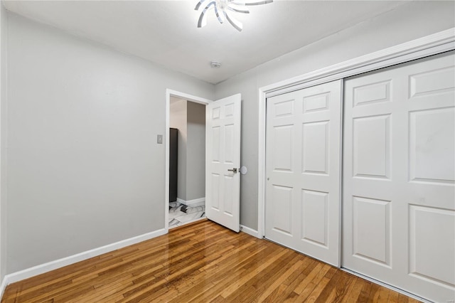 unfurnished bedroom featuring wood-type flooring and a closet