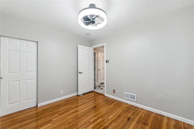 unfurnished bedroom featuring hardwood / wood-style flooring and a closet