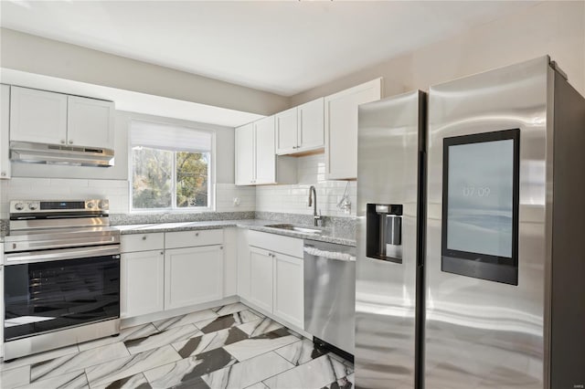 kitchen featuring stainless steel appliances, white cabinetry, tasteful backsplash, and sink