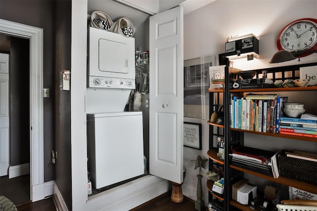 laundry area featuring stacked washing maching and dryer and hardwood / wood-style flooring