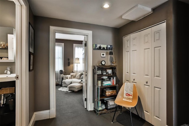 office space featuring dark colored carpet and sink