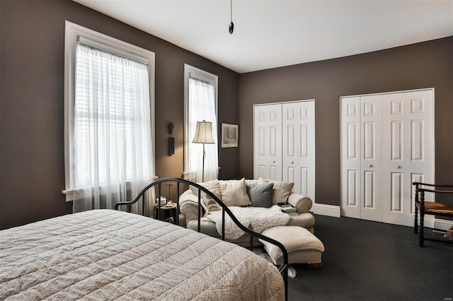 bedroom with multiple windows and two closets