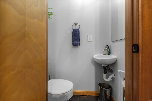 bathroom with toilet, tile patterned floors, and sink