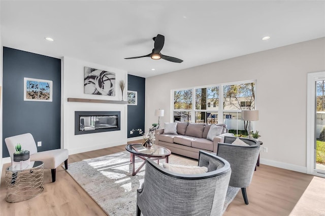 living room featuring ceiling fan, hardwood / wood-style flooring, and a healthy amount of sunlight