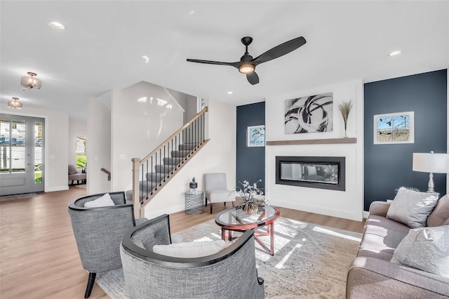 living room featuring ceiling fan and light hardwood / wood-style floors