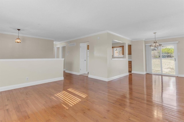 unfurnished room with a notable chandelier, ornamental molding, and light hardwood / wood-style floors