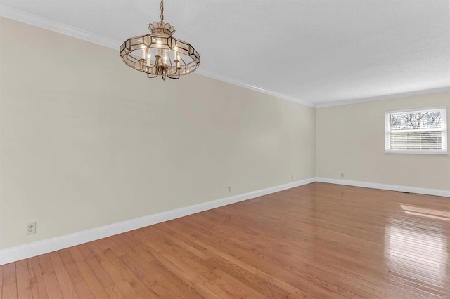 unfurnished room featuring crown molding, a chandelier, and light wood-type flooring