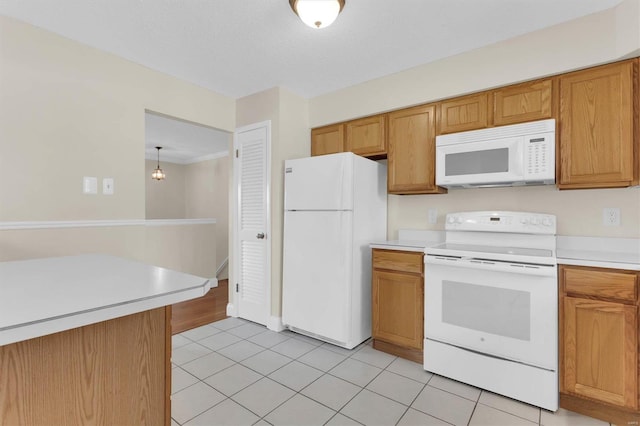 kitchen featuring hanging light fixtures, white appliances, light tile patterned floors, and a textured ceiling