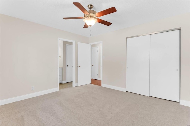 unfurnished bedroom featuring light carpet, a closet, and ceiling fan