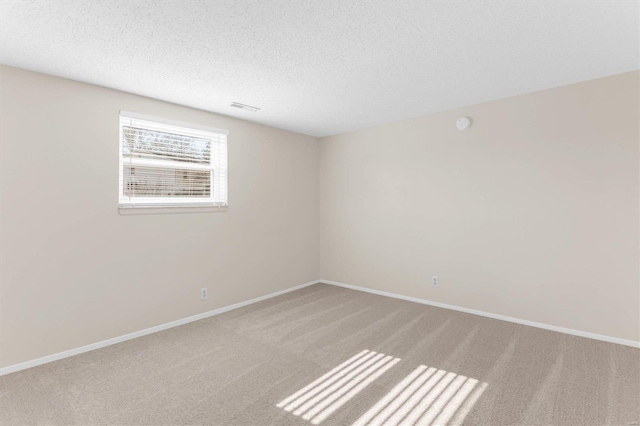 empty room featuring light carpet and a textured ceiling