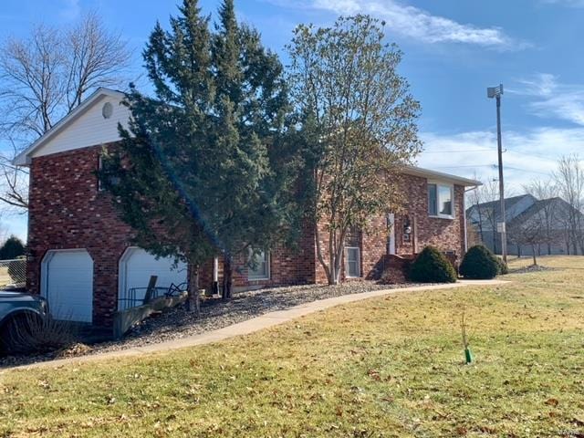 view of side of home featuring a garage and a yard