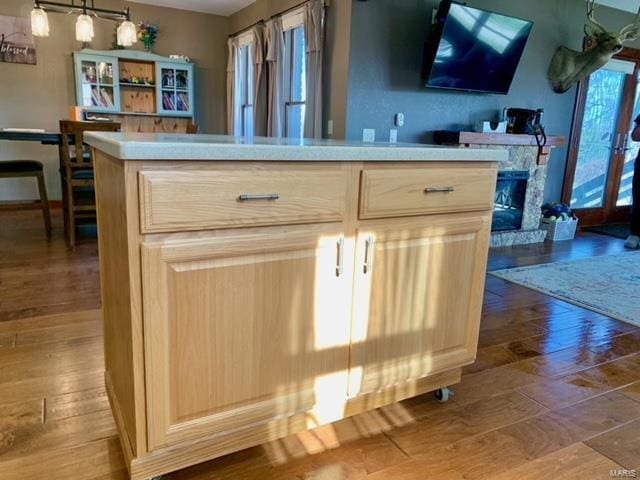 bar featuring pendant lighting, light brown cabinetry, and hardwood / wood-style floors