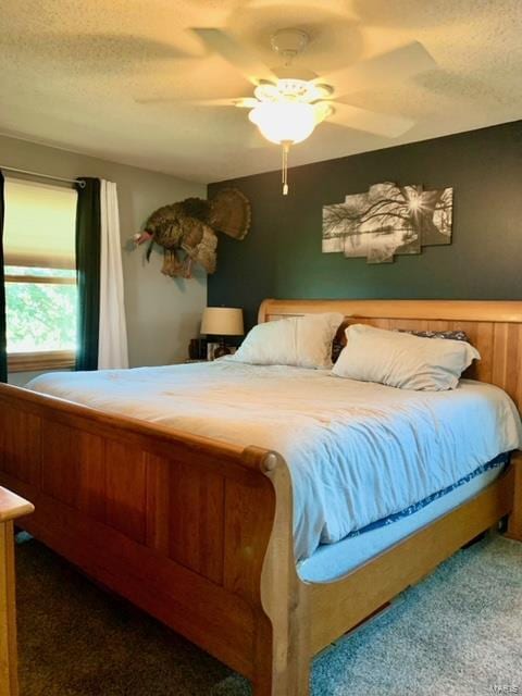 bedroom featuring ceiling fan, carpet floors, and a textured ceiling